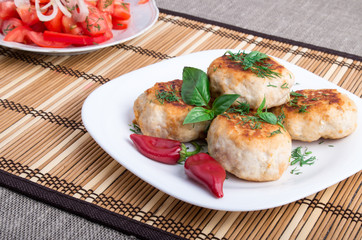 Chicken meatballs of minced meat and a salad of raw tomatoes