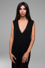 Sexy Beautiful Brunette Woman In Black Dress Isolated On Gray Background
