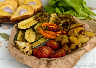 A lot vegetables grilled on a dish (potatoes, tomatoes, carrots, onions, zucchini)