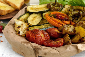 A lot vegetables grilled on a dish (potatoes, tomatoes, carrots, onions, zucchini)