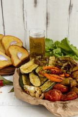 A lot vegetables grilled on a dish (potatoes, tomatoes, carrots, onions, zucchini)