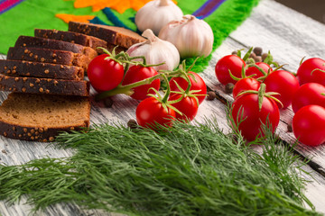 Still life of tomatoes, black bread, garlic, fennel, pepper