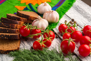 Still life: tomatoes, black bread, garlic, fennel and bayberry