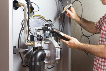 plumber repairing a condensing boiler in the boiler room