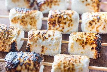 Marshmallow skewers on the wooden background