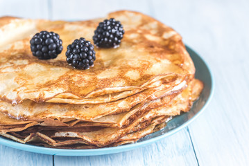 Crepes with blackberries on the wooden table