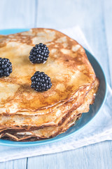 Crepes with blackberries on the wooden table