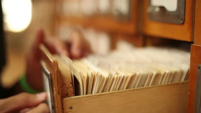 man finding needful information in catalog in a library, close up
