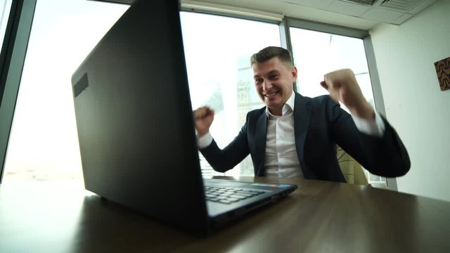 very emotional businessman enjoys good news,to receive e-mail, stocks rise in price