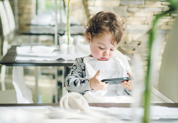 Cute child playing games on with a smartphone