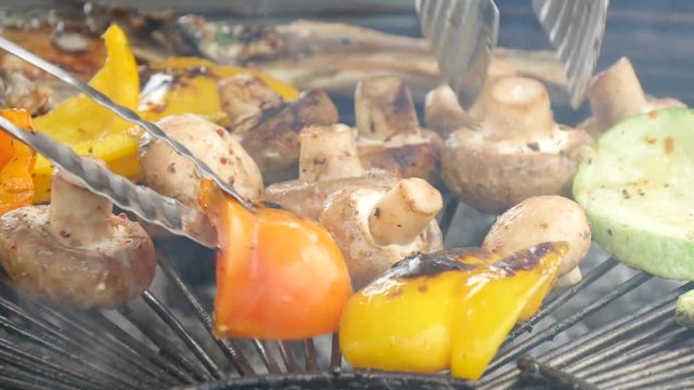cooking meat, mashrooms and vegetables on a grill