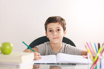 Candid portrait of a boy doing his homework and studying at home