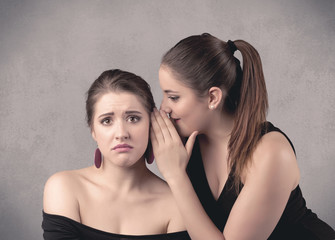 girl telling secret things to her girlfriend