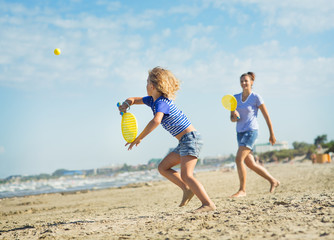 Girl playing with her mother in tennis