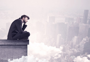 Sales person sitting on building edge in city