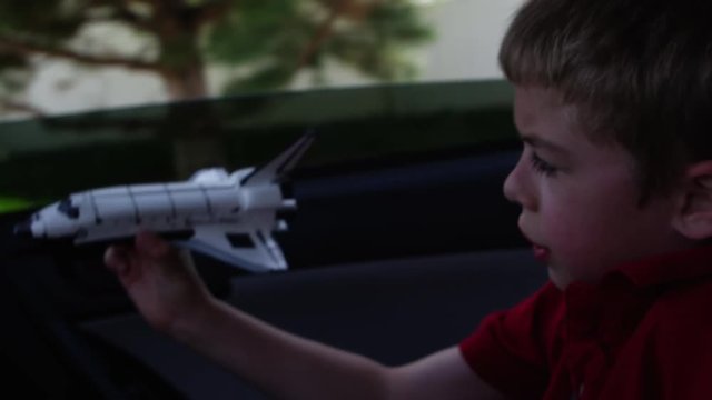 Closeup of boy playing with toy shuttle