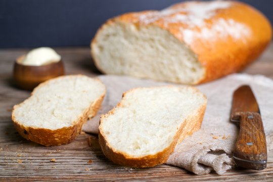 Sliced loaf of homemade bread on wooden background