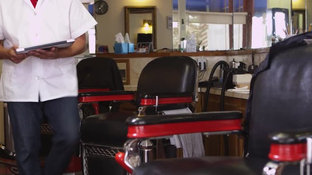 Barber using laptop in shop