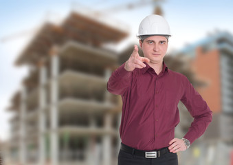 A man in a white construction helmet on a building background