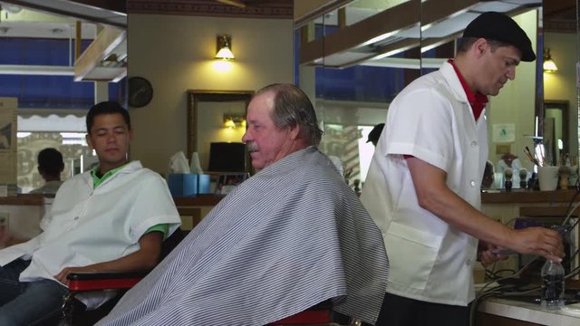 Elderly man in barber shop getting haircut
