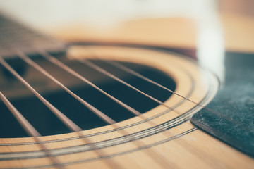 closeup picture of an acoustic guitar in a film tone, vintage style