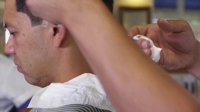 Closeup of man getting haircut at barber shop