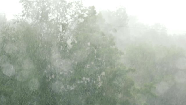 drops on window with heavy rain handheld shot in slow motion