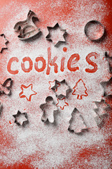 Christmas red background with cutters for cookies