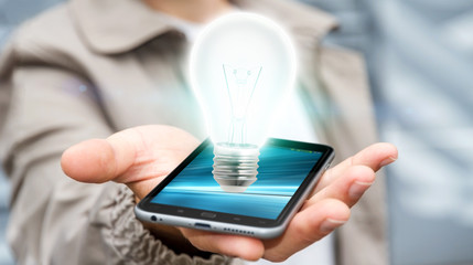 Businessman holding shiny lightbulb on mobile phone ‘3D render