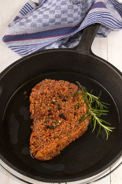 raw peppered pork chop in a cast iron pan