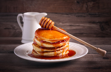 Honey stick coated with honey over pancakes