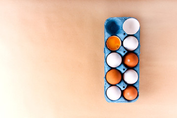 White and brown eggs in cupboard box, top view