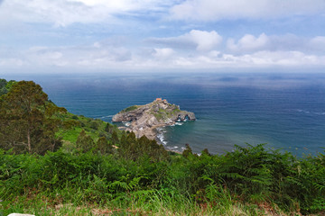 View from the coast on the rock in the ocean with a chapel Donie