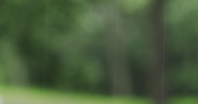 rain falling in fron of defocused green town background