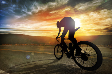 Man riding a bike in high mountains at sunset. Extreme sport, sp