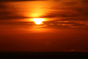 Setting summer sun against an orange sky