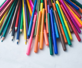 colored pencils and felt-tip pens on a white background