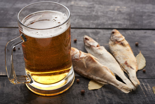 Dried fish and beer glass on a wooden table in a pub