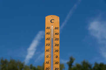 Thermometer im Sommer mit blauen Himmel im Hintergrund