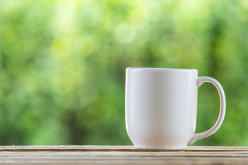 coffee mug wooden tabletop against grunge green blur background
