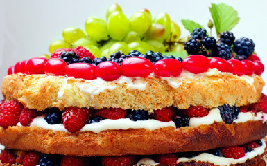 Naked cake with cream, decorated with raspberries, blackberries,