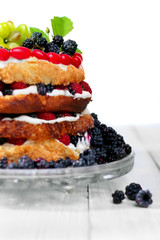 Naked cake with cream, decorated with raspberries, blackberries,