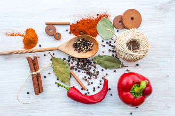 Colorful pepper in a wooden spoon over rustic wooden background