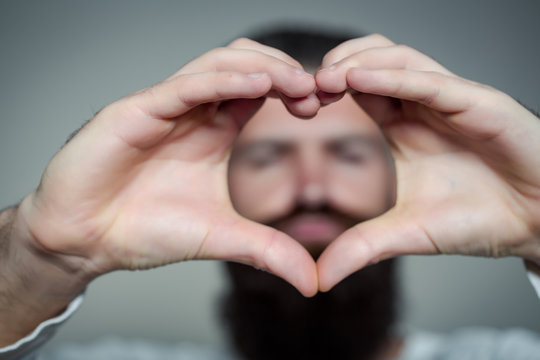 Bearded man with hands in heart shape