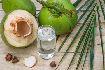 Fresh Coconut Water Drink with coconut leaf on wooden  background