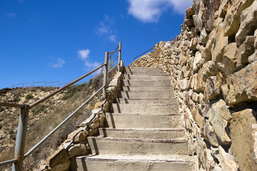 Concrete stairs up to hill and blue sky