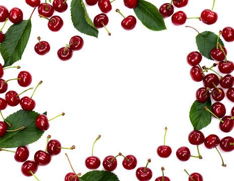 Frame of red juicy cherries with leaves on a white background with space for text. Flat lay
