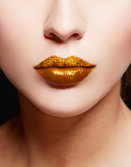 Gold lips. Closeup of golden lipstick. Cosmetic makeup image. 