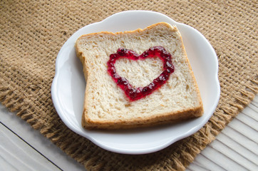 one slice of wheat bread isolated with jam heart sign on the tab