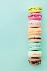 Foto auf Acrylglas Macarons Kuchen Makronen oder Makronen auf blauem Hintergrund von oben. Bunte Mandelkekse. Vintage-Karte. Flach liegen.